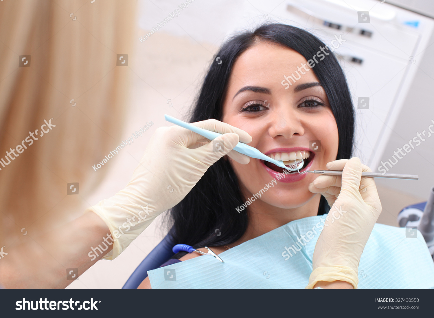 Dentist examining a patient's teeth in the dentist. #327430550