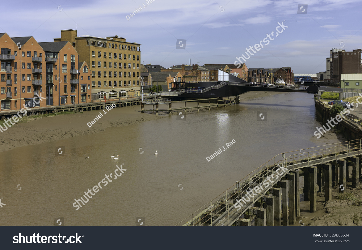 Hull, Humberside, UK. River Hull at low tide with view of Scale Lane swing bridge (open), beached obsolete ship, and flanked by buildings near the estuary, Hull, Humberside, UK. #329885534