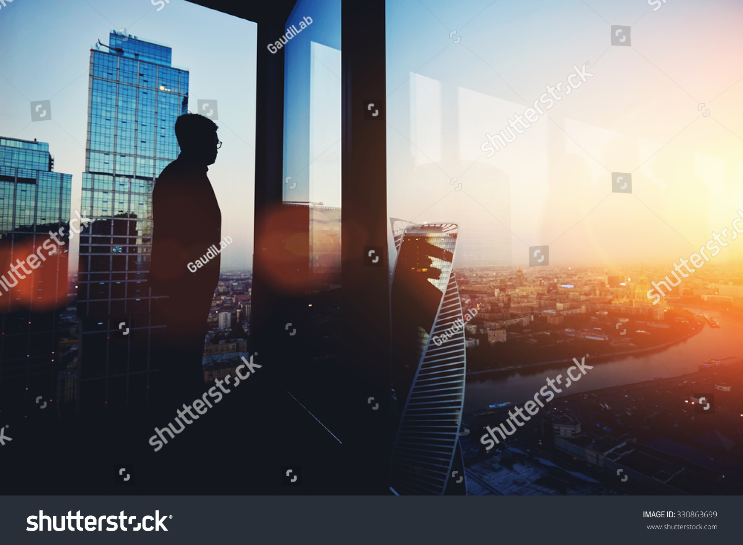 Silhouette of young intelligent man managing director resting after late business meeting while standing near big office window background with copy space for your text message or promotional content #330863699