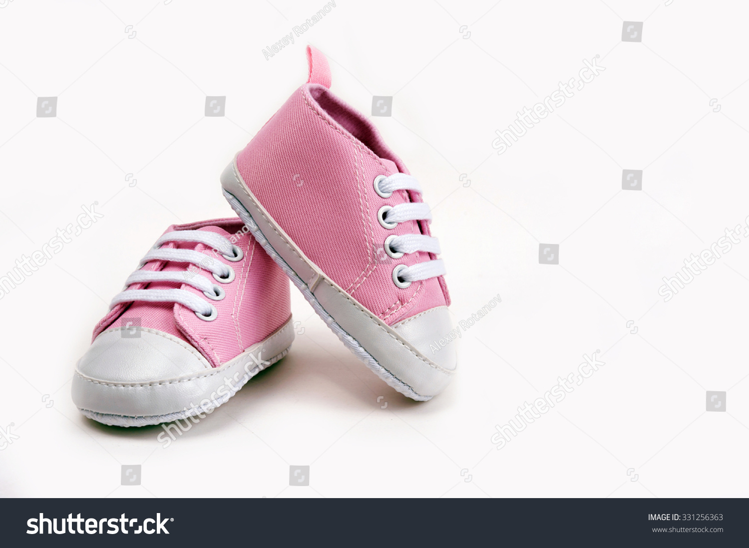 Cute pink baby girl sneakers close up on gray background #331256363