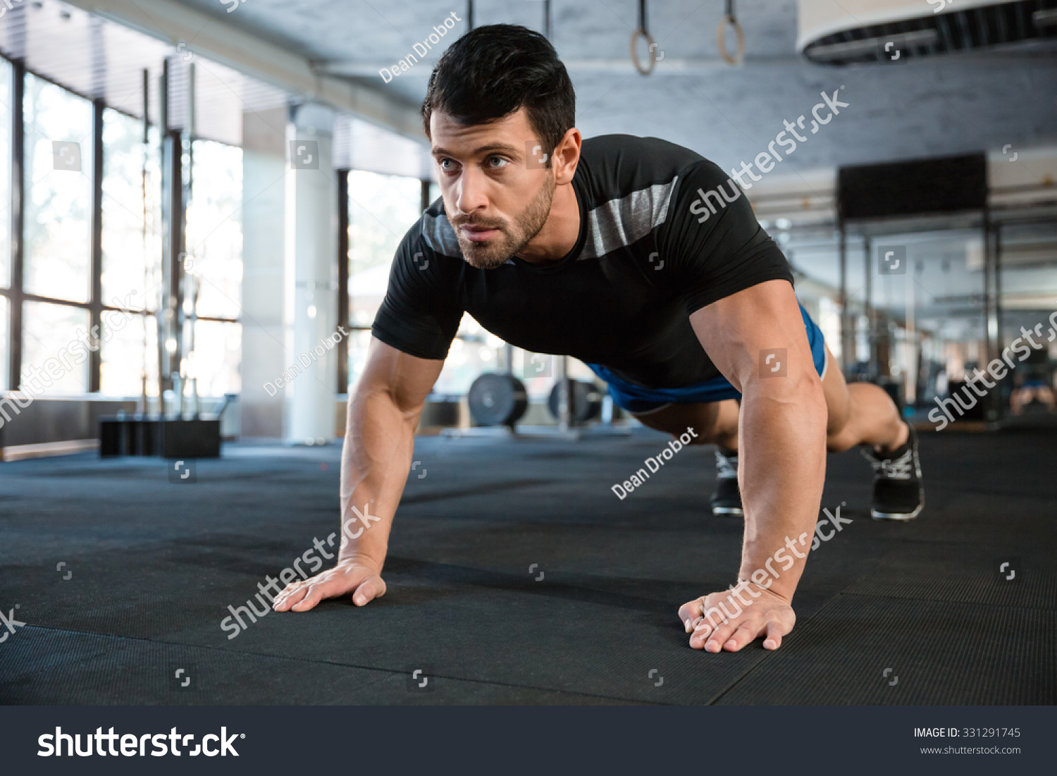 Sportsman wearing blue shorts and black t-shirt doing push-ups #331291745