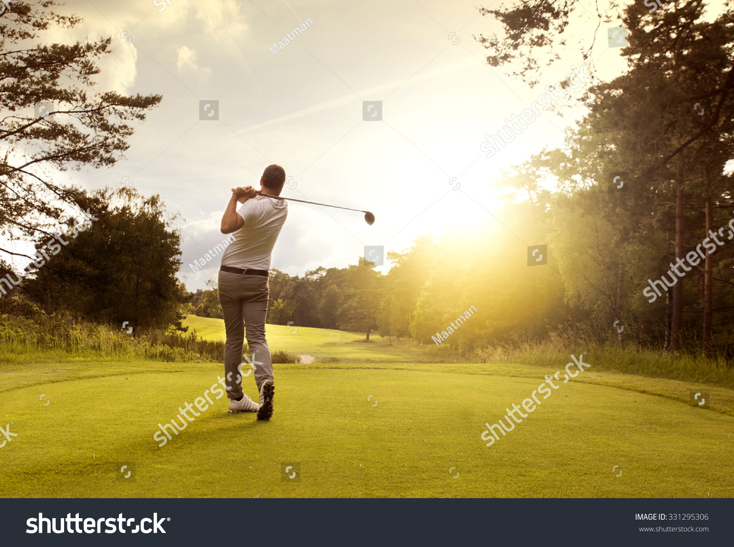 Man playing golf on a golf course in the sun #331295306