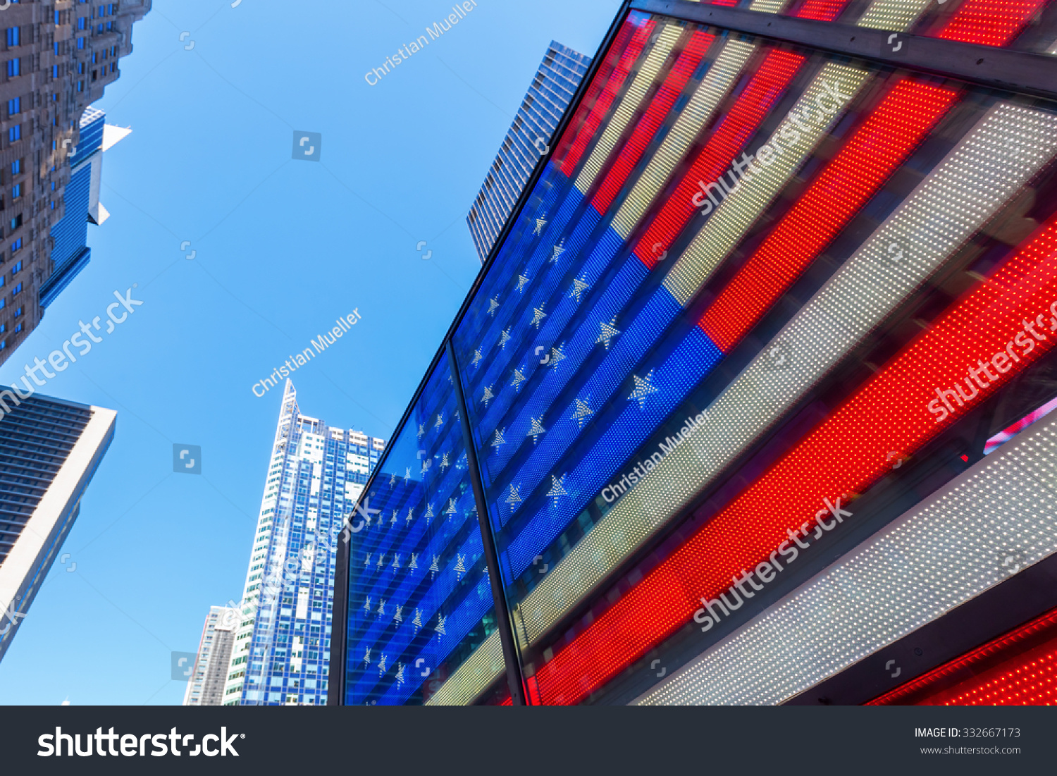 NEW YORK CITY - OCTOBER 10, 2015: neon US flag at Times Square. Times Square is one of the worlds busiest pedestrian intersections and a major center of worlds entertainment industry #332667173