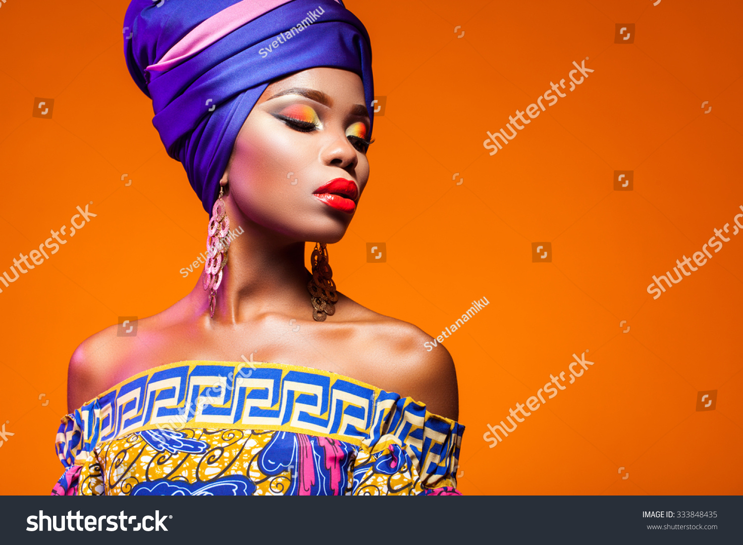 African woman in a bright dress on orange background #333848435