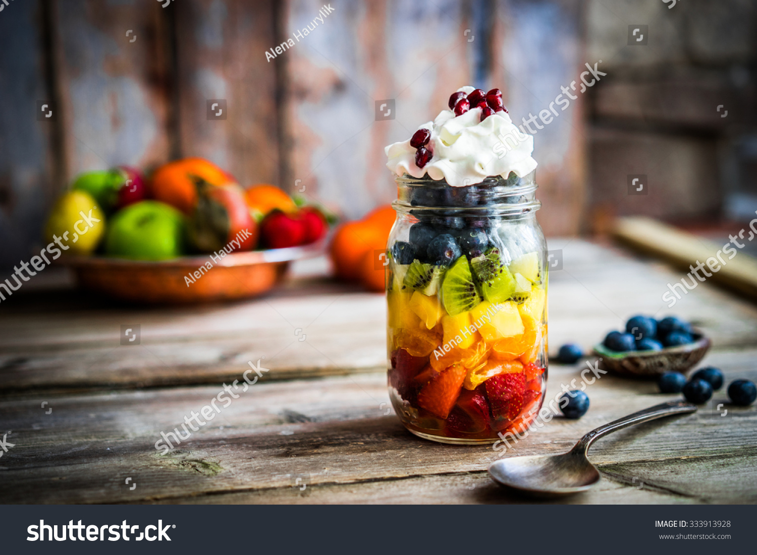 Colorful fruit salad in a jar on rustic wooden background #333913928