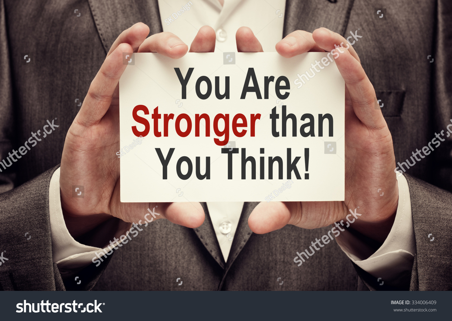 You Are Stronger Than You Think ! Motivational Message written on a card in hands of a businessman #334006409