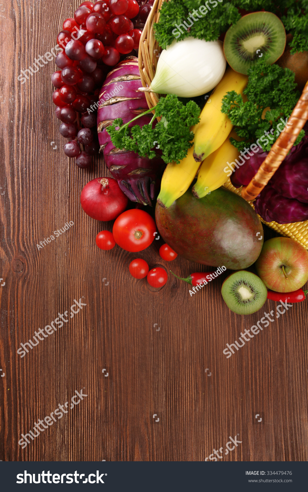A set of fruit and vegetables in a basket on wooden background #334479476