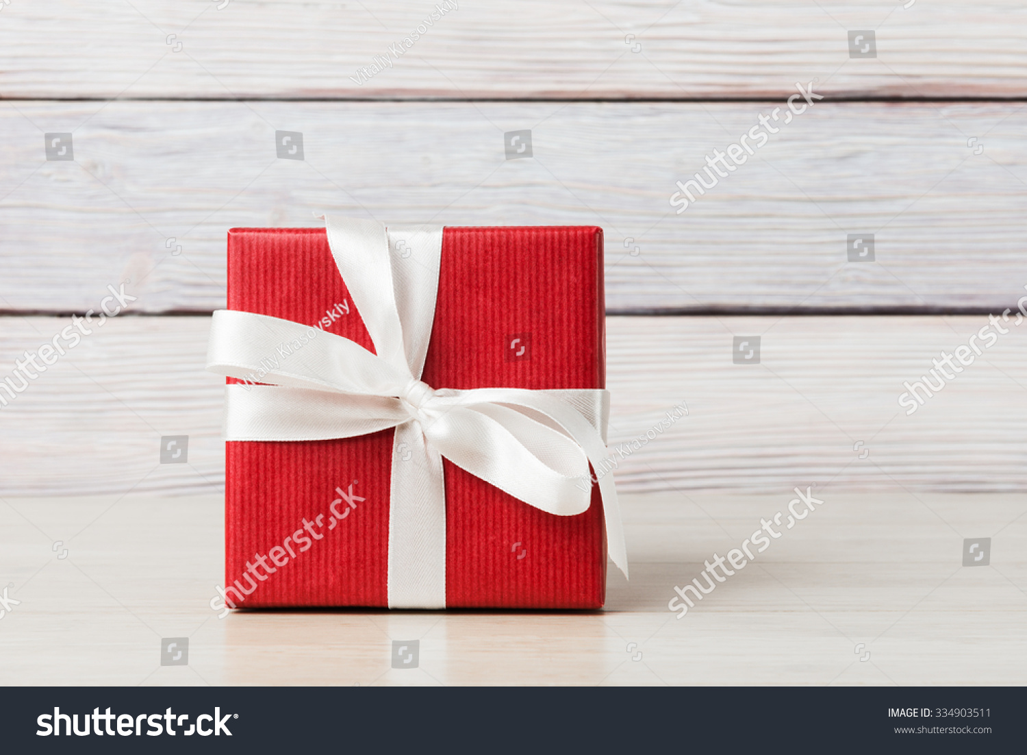 Gift box over light wooden background #334903511