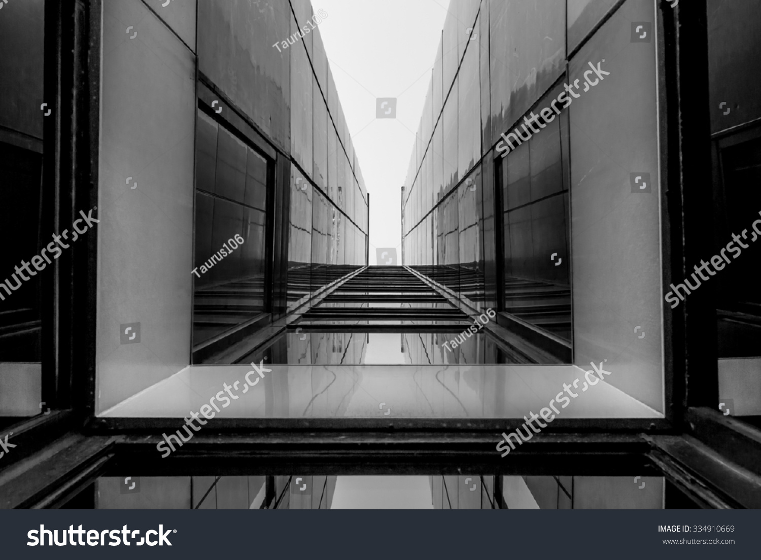 Urban Geometry, looking up to glass building. Modern architecture, glass and steel. Abstract architectural design. Inspirational, artistic image. Industrial design. .Modern building. Black and white. #334910669