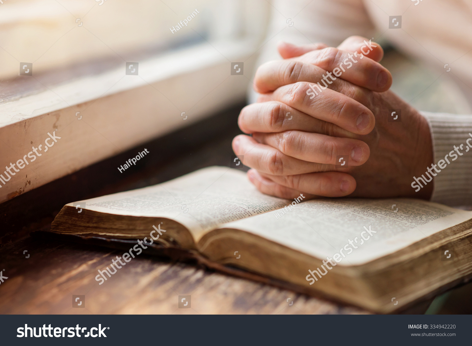 Unrecognizable woman holding a bible in her hands and praying #334942220