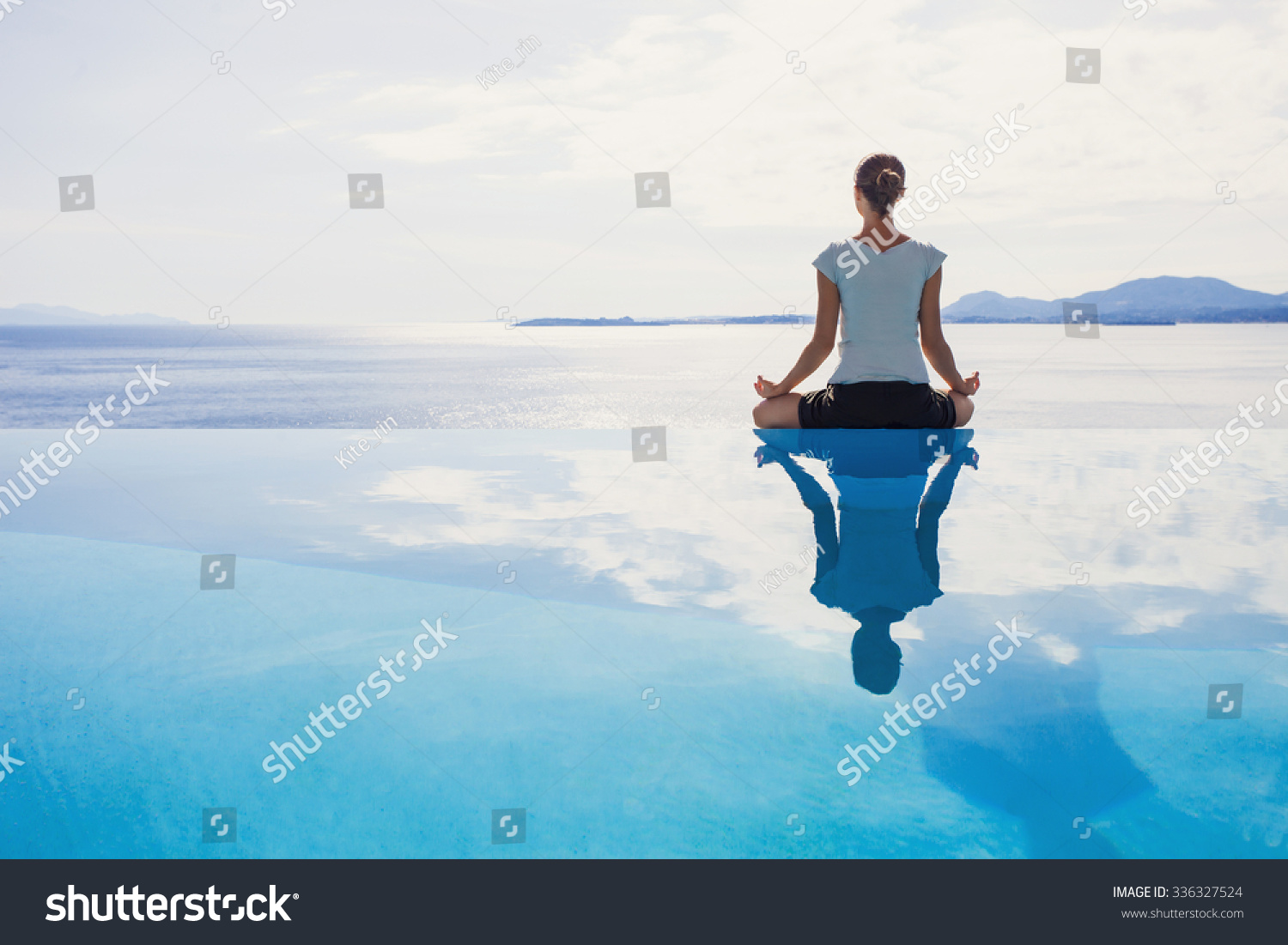 Young woman practicing yoga. Beautiful girl meditating, doing breathing exercises. Harmony, balance, meditation, relaxation, mindfulness, recreation, self care, body care, healthy lifestyle concept #336327524
