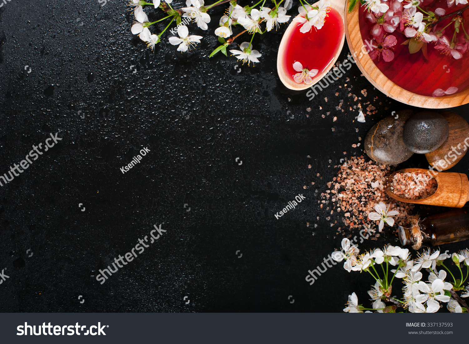 Spa concept on a dark background. Sea salt, flowering branches of cherry, aromatic oils #337137593