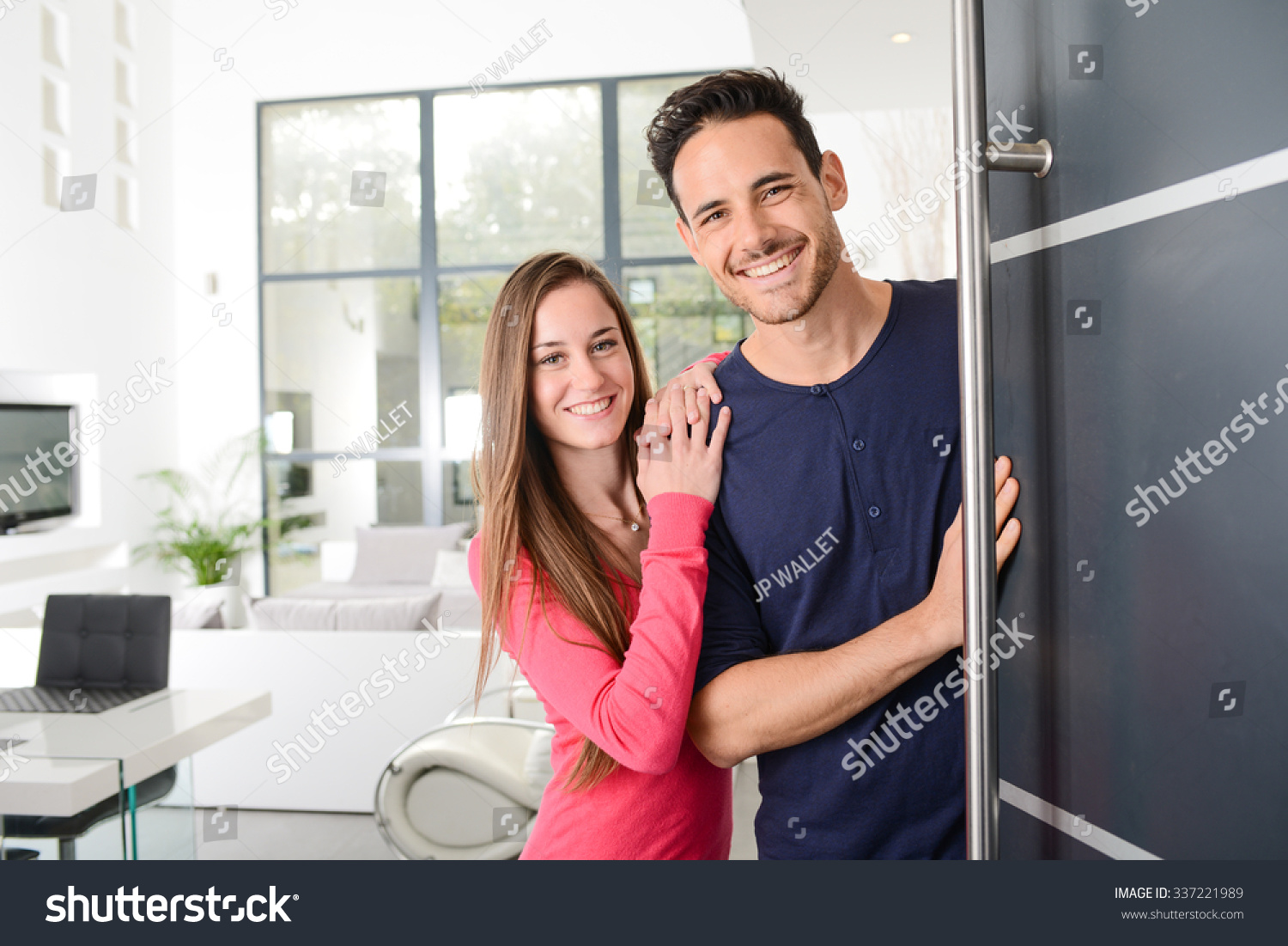happy young couple at new house front door welcoming people  #337221989