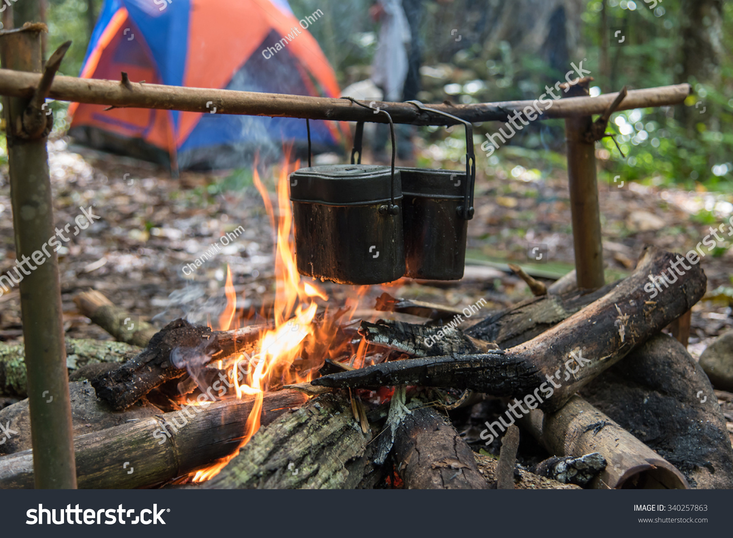 Rice cooking with army pot by using bonfire while camping in the forest. #340257863