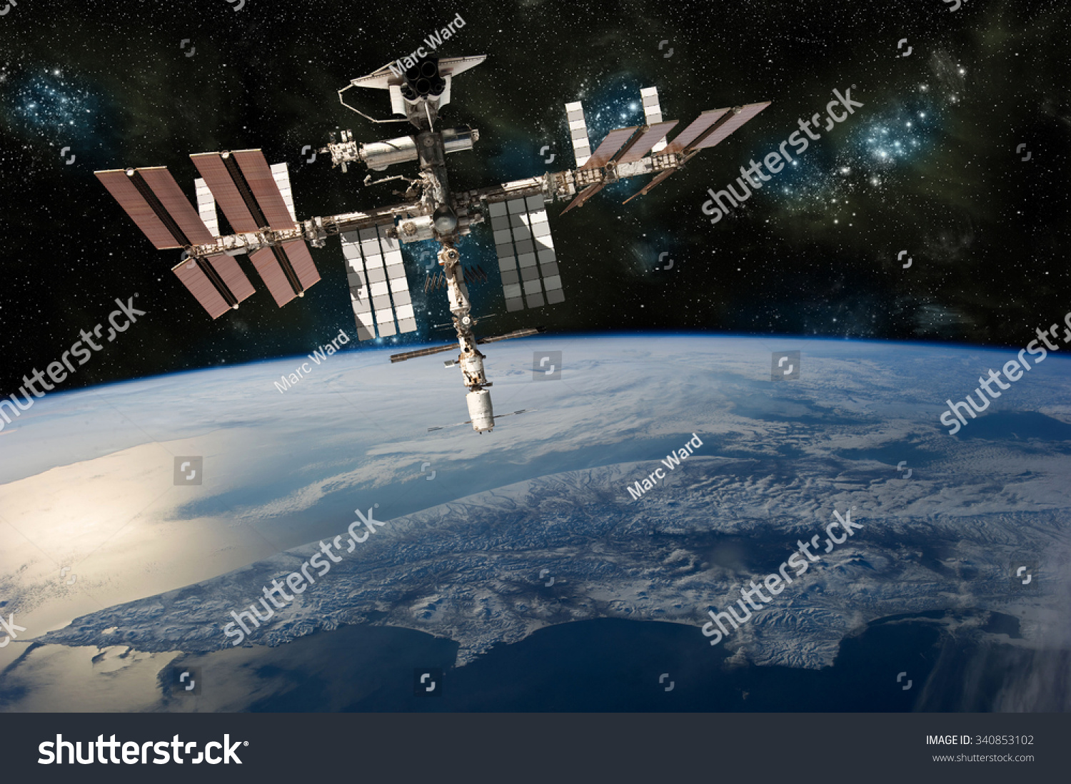 A depiction of the space shuttle docked at the international space station orbiting Earth. -  Elements of this image furnished by NASA #340853102