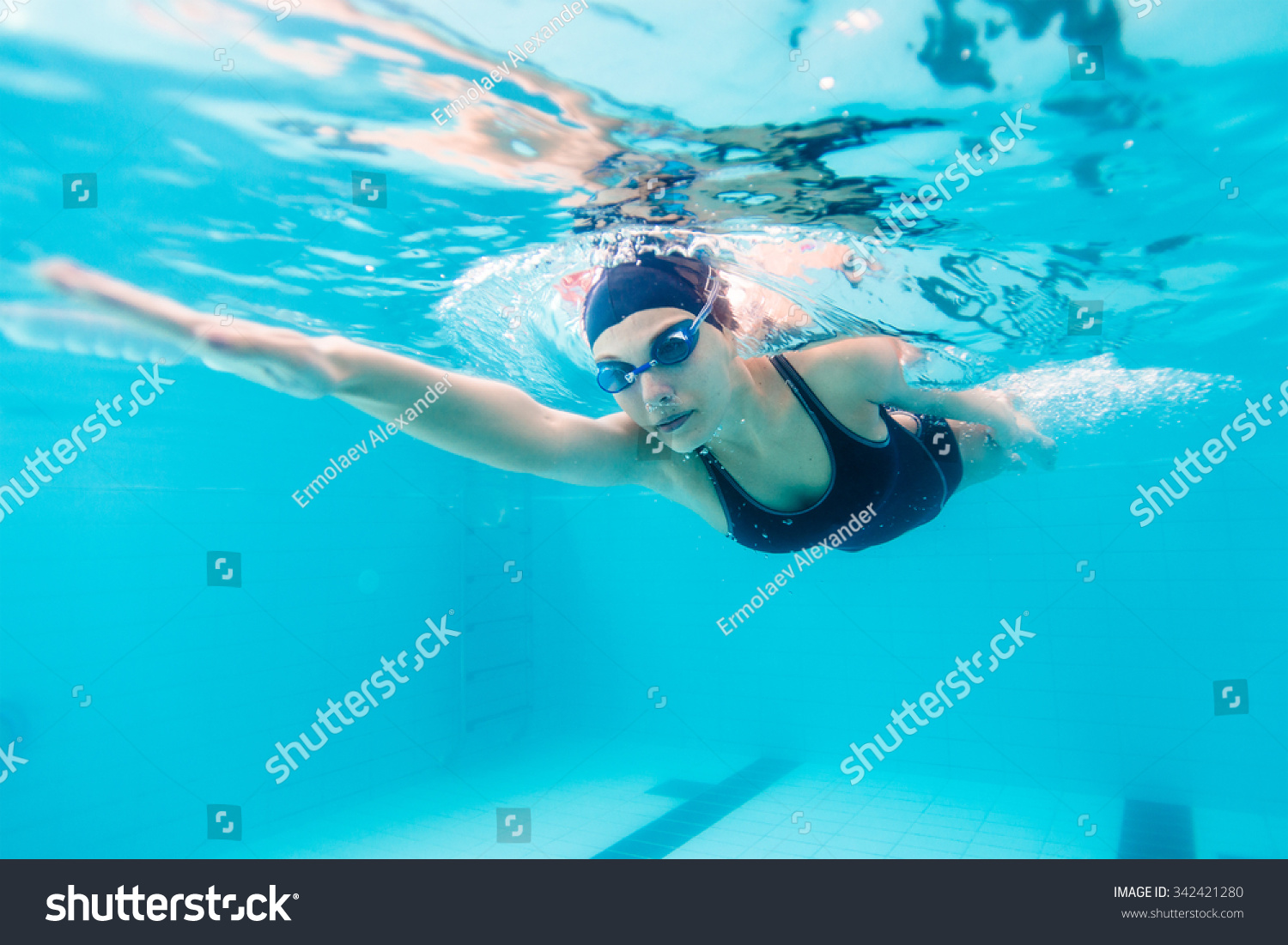 Female swimmer gushing through water in pool #342421280