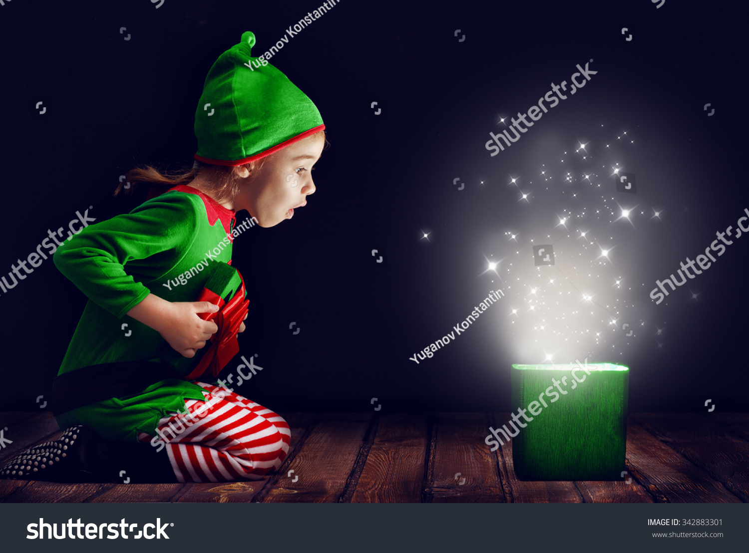 Cute little girl opening a magic gift box. #342883301