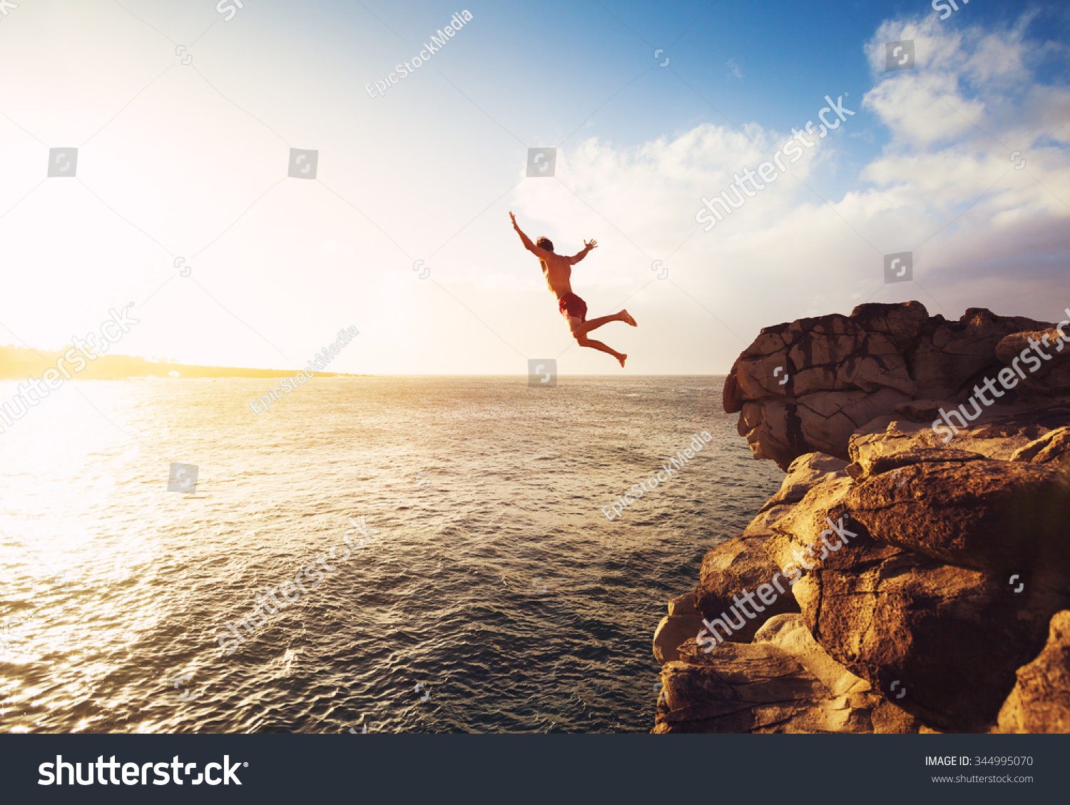 Cliff Jumping into the Ocean at Sunset, Summer Fun Lifestyle #344995070