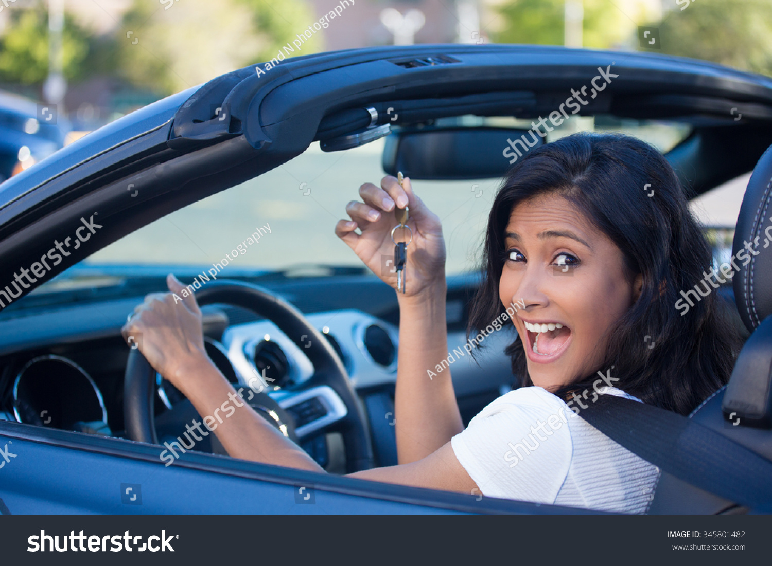 Closeup portrait, young cheerful, joyful, smiling, gorgeous woman holding up keys to her first new sports car. Customer satisfaction #345801482