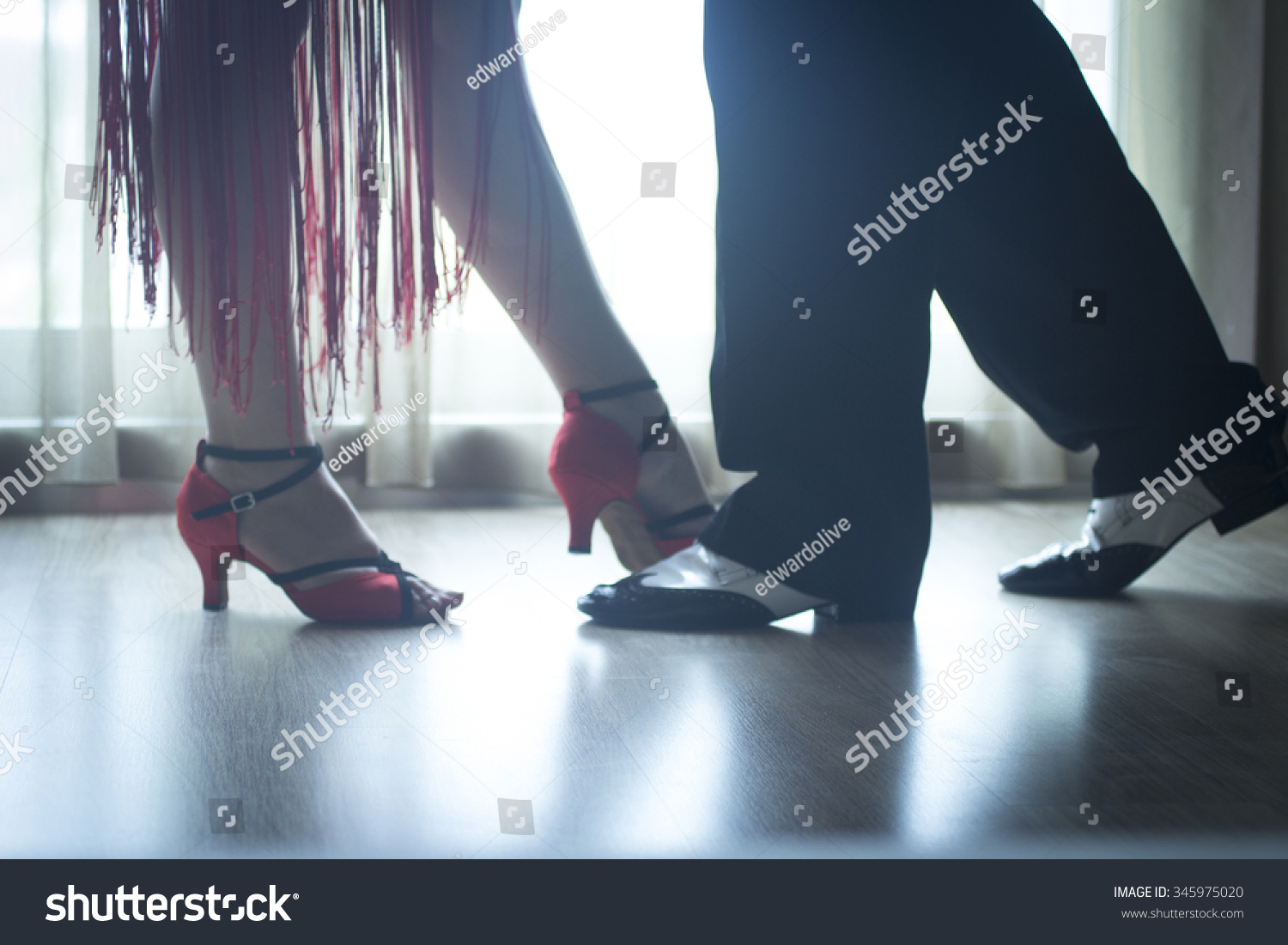Dancing shoes feet and legs of female and male couple ballroom and latin salsa dancer dance teacher in dance school rehearsal room class. #345975020