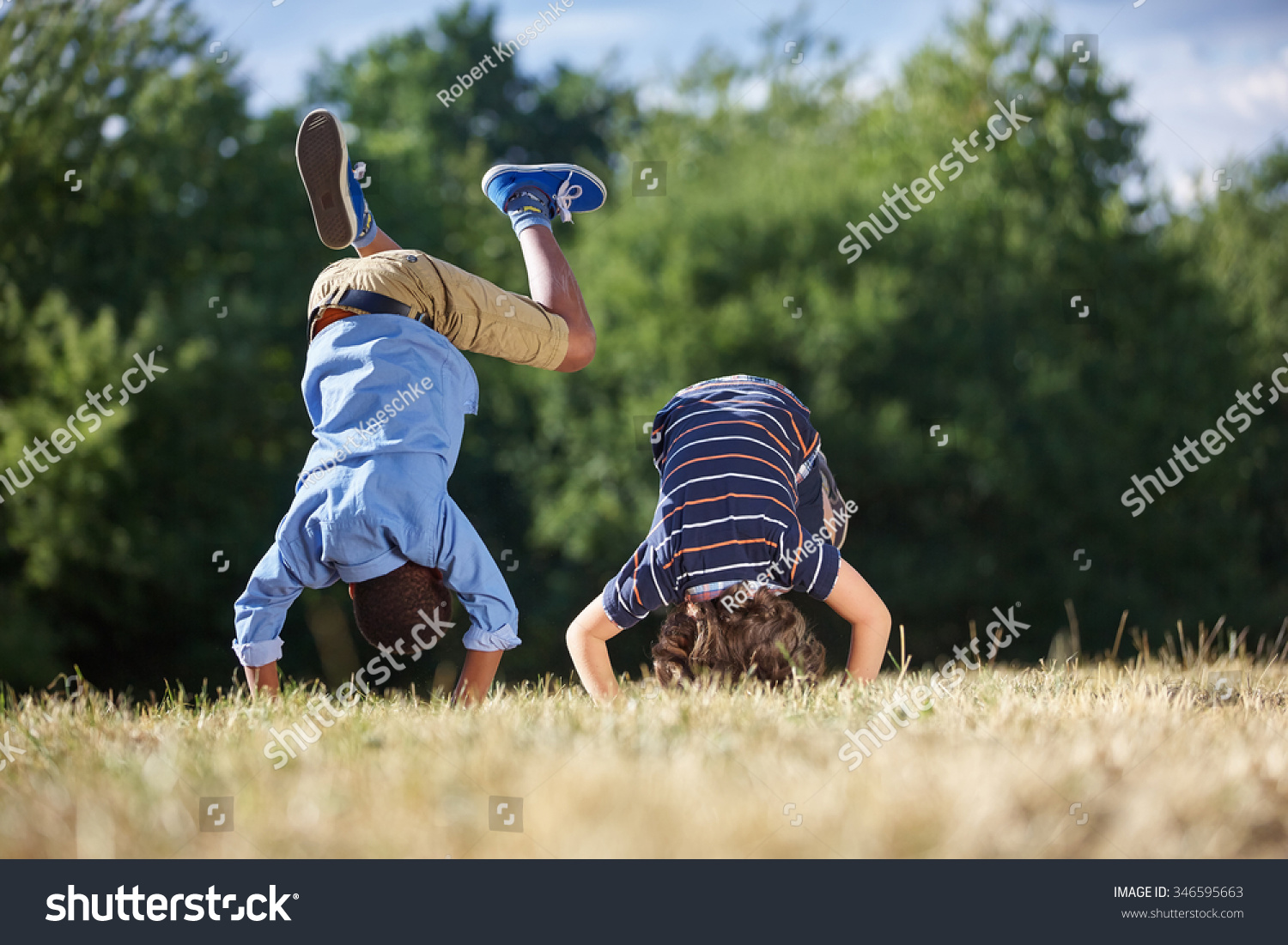 Two boys making a somersault and having fun at the park #346595663