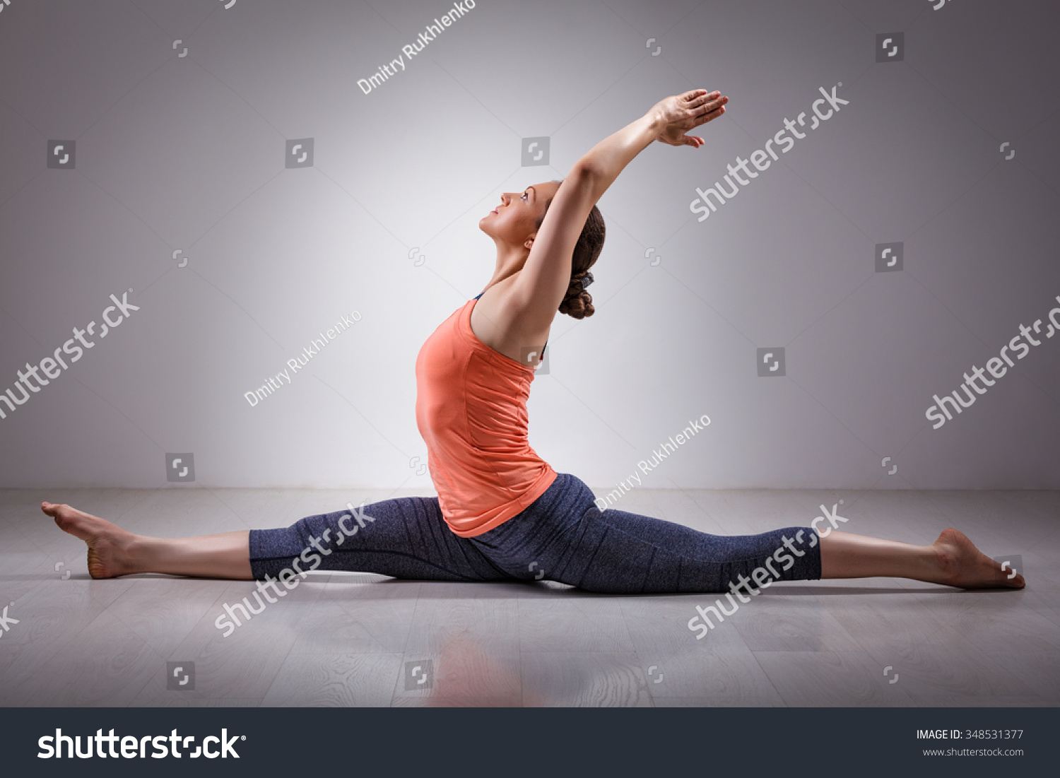 Sporty fit woman doing Hatha yoga asana Hanumanasana  (splits) - monkey pose #348531377
