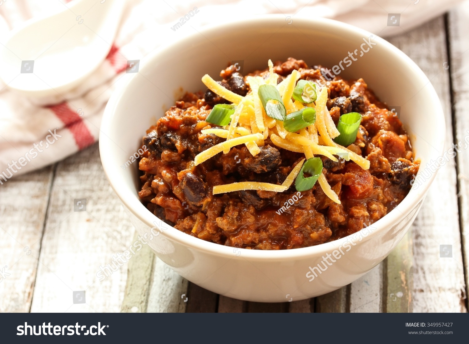 Beef chili  / Bowl of beef chili with cheddar cheese on top #349957427