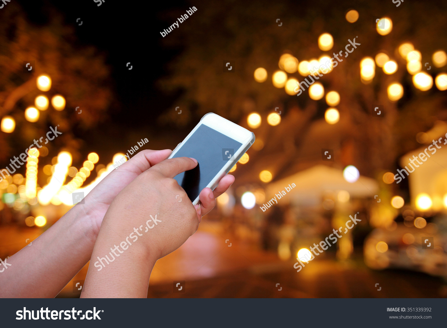 hand hold and touch screen smart phone, on abstract  blurred photo night festival on street #351339392