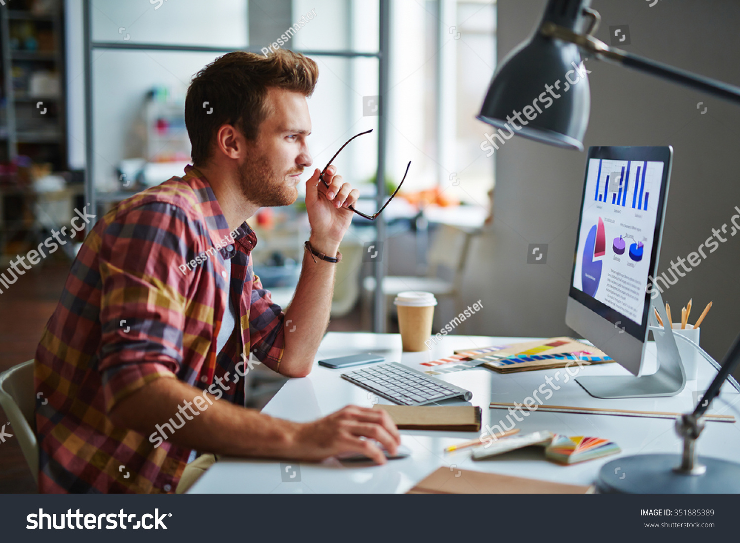 Man as a designer sitting at his table and working on computer #351885389