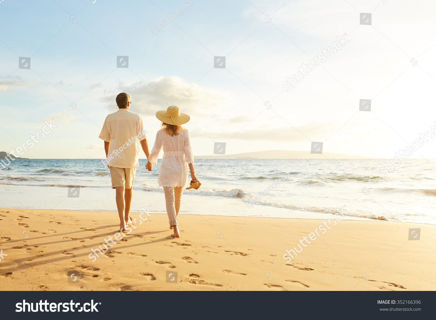 Happy Romantic Middle Aged Couple Enjoying Beautiful Sunset Walk on the Beach. Travel Vacation Retirement Lifestyle Concept #352166396