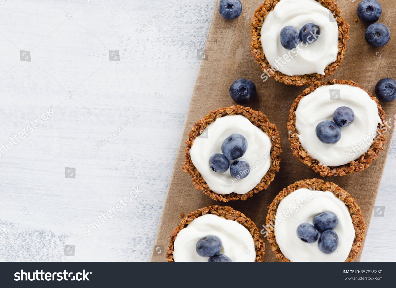 Blueberry tarts on a wooden platter, healthy dessert tart snack #357835880