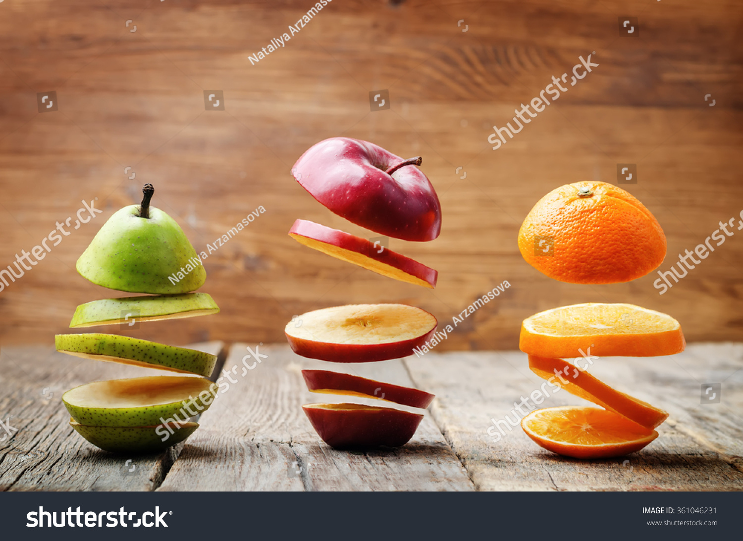 flying slices of fruit: apple, pear, orange on a dark wood background. toning. selective Focus #361046231