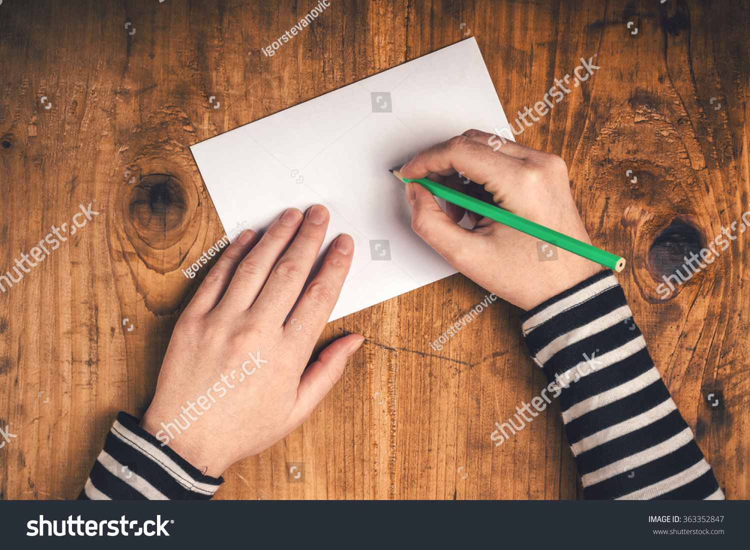 Woman writing recipient address on mailing envelope, female hands from above on office desk sending letter, top view, retro toned. #363352847