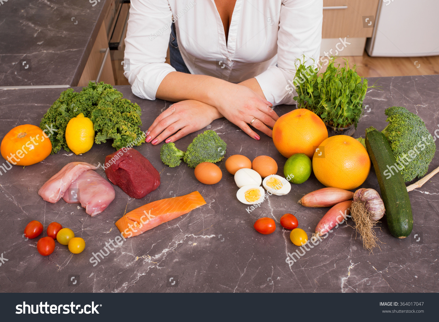 Woman in kitchen with different raw foods  #364017047