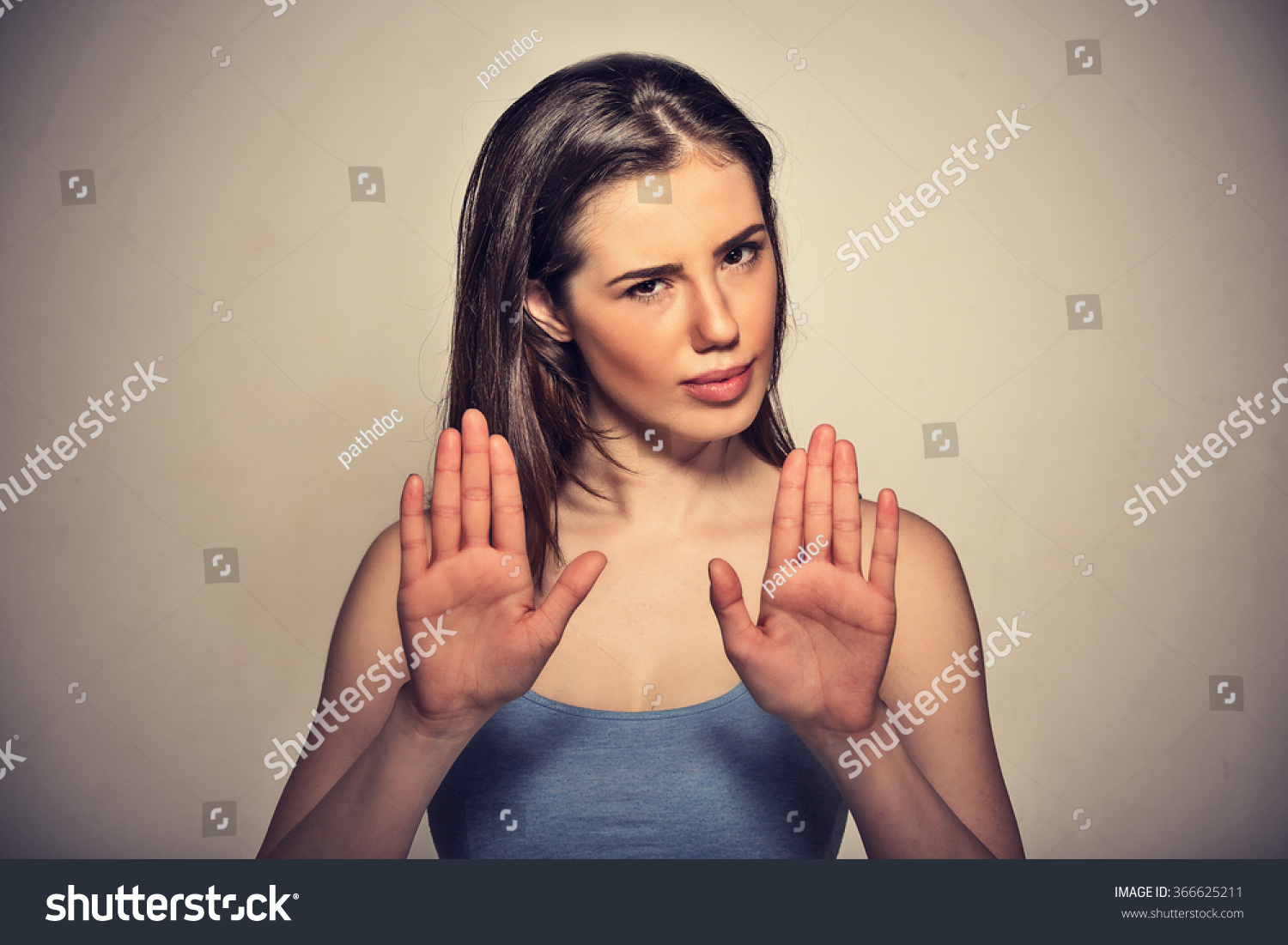 Closeup portrait young annoyed angry woman with bad attitude gesturing with palms outward to stop isolated on grey wall background. Negative human emotion face expression feeling body language #366625211