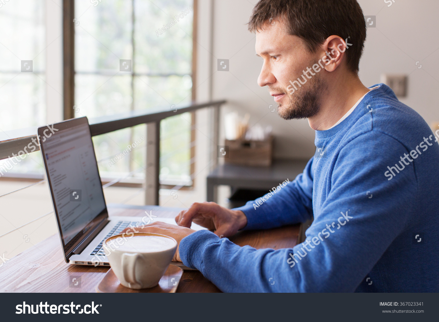 positive man working on laptop computer in cafe drinking coffee, lifestyle concept #367023341