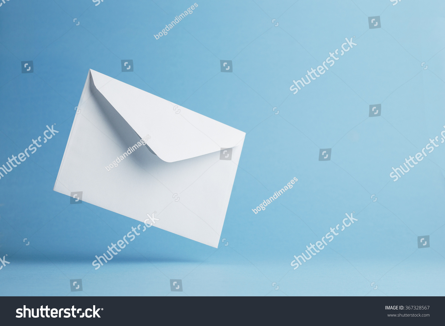 Envelope falling on the ground, blue background with negative space #367328567