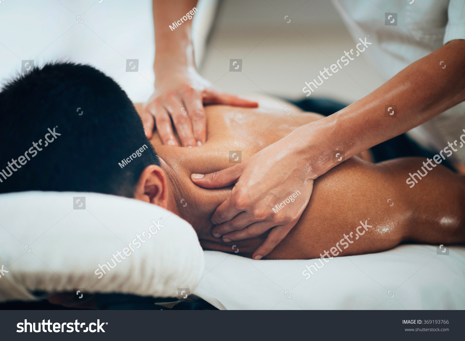 Sports massage. Massage therapist massaging shoulders of a male athlete, working with Trapezius muscle. Toned image #369193766