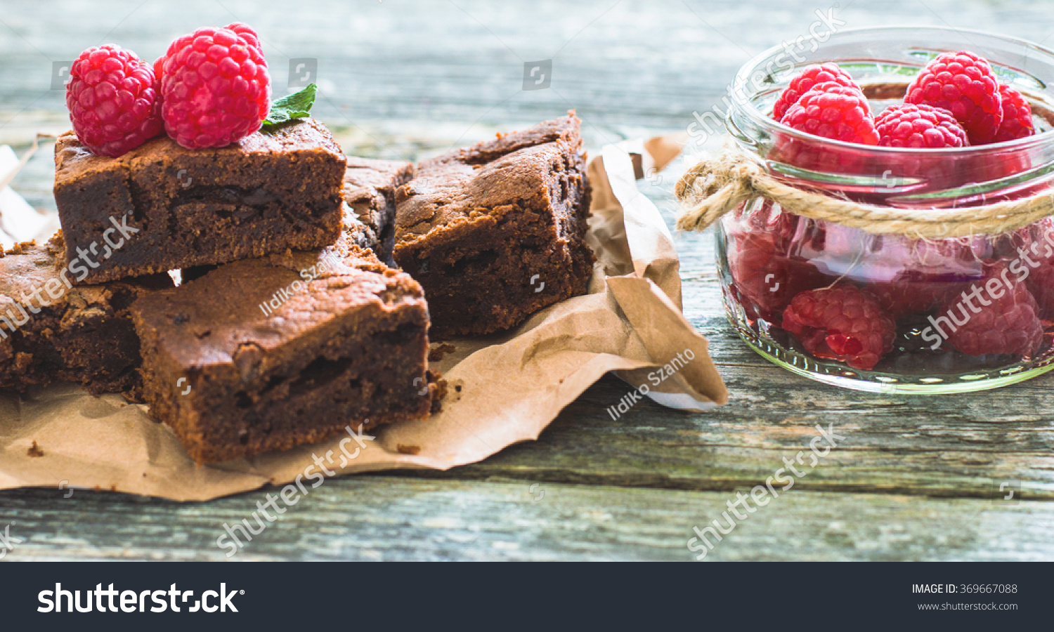 Chocolate brownies with raspberry on a wooden background #369667088