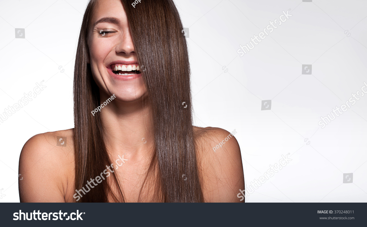 Laughing girl with shiny black hair and perfect clean skin on a white background #370248011