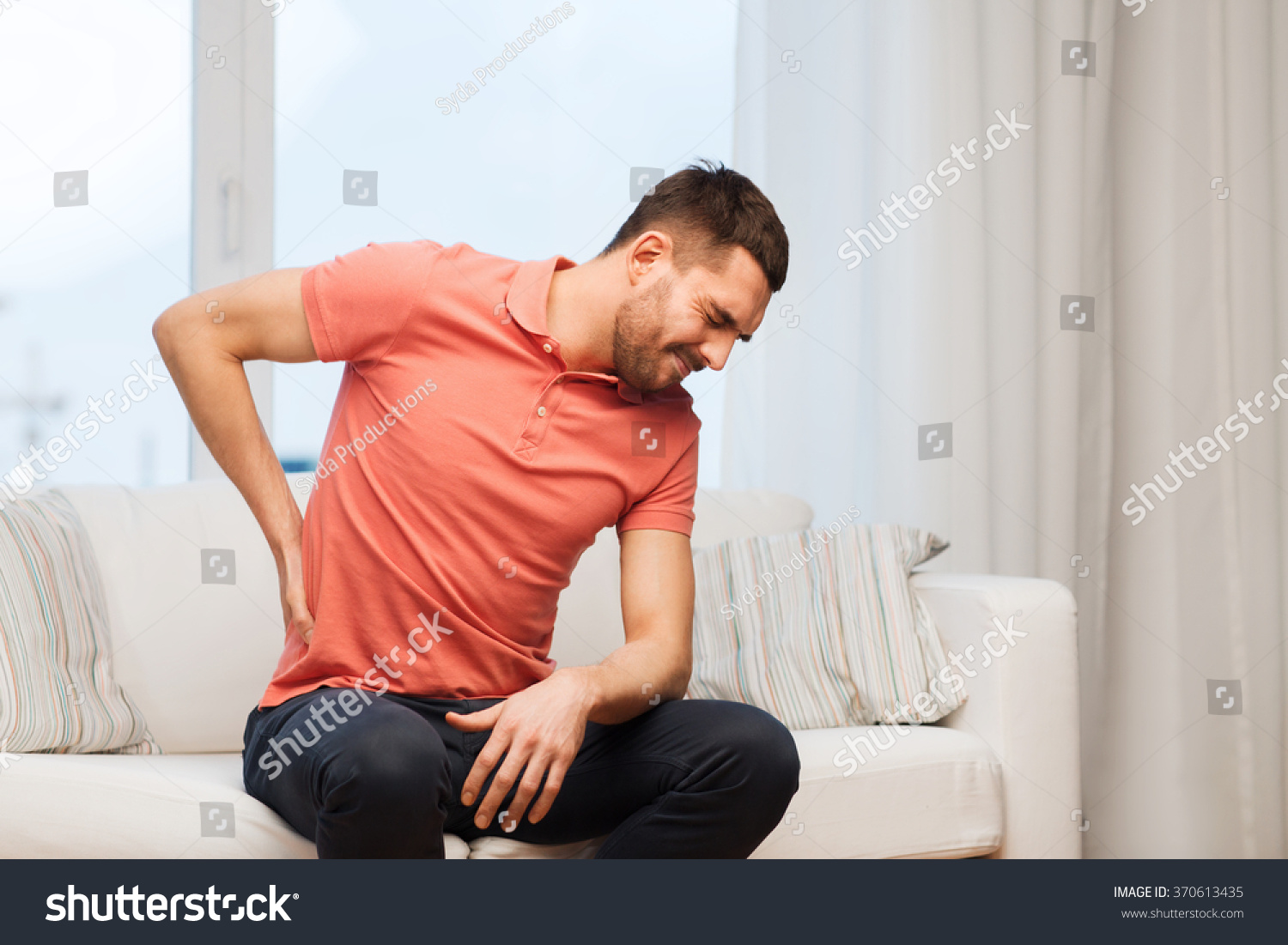 unhappy man suffering from backache at home #370613435