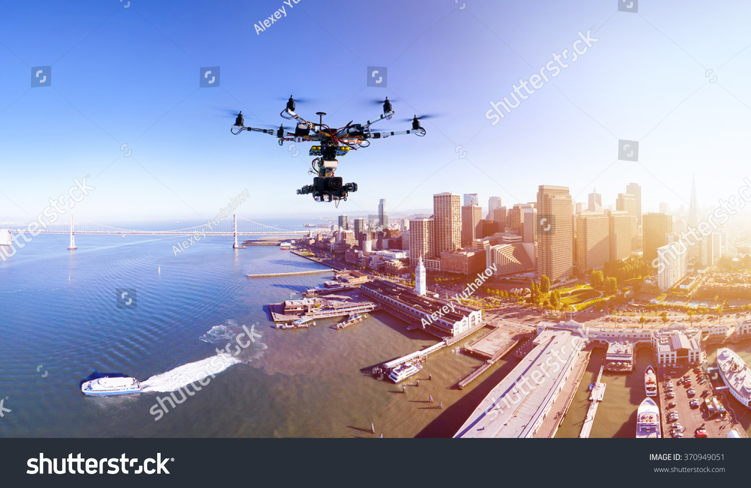 Professional photography drone with the cinema camera flying over San-Francisco pears and the financial district at the summer sunset. Remote control photography innovations concept. #370949051
