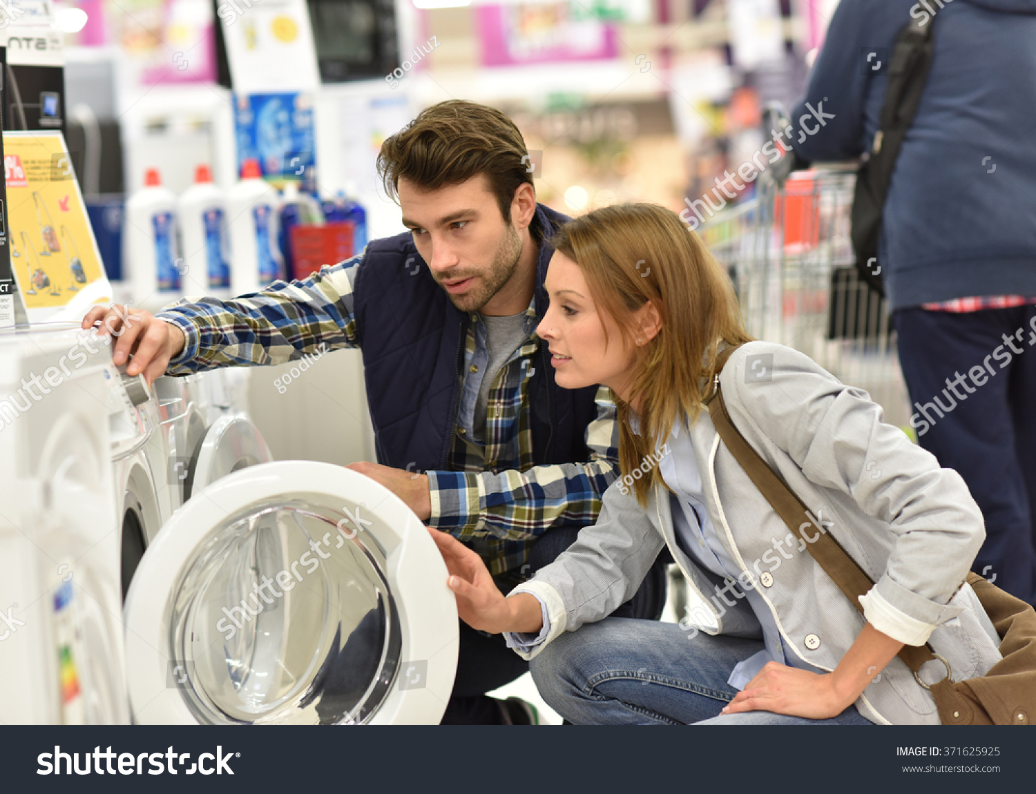 Seller helping customer with choosing washing machine #371625925