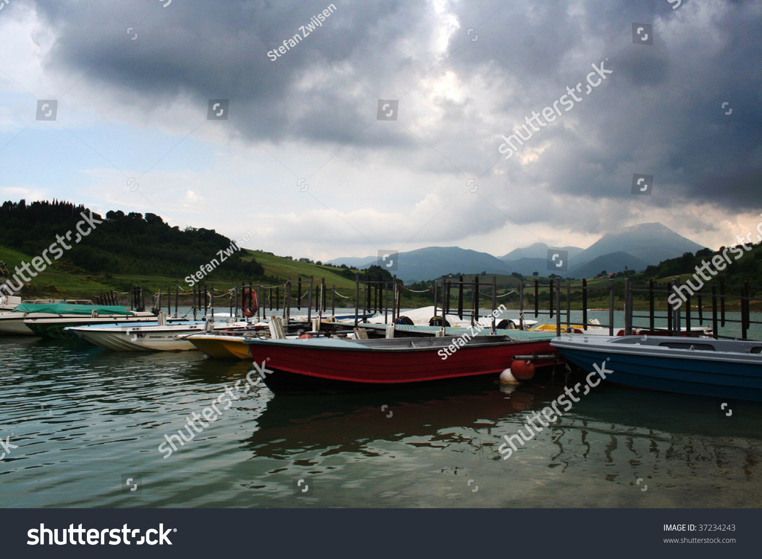 Boats on a lake with mountains in the background #37234243