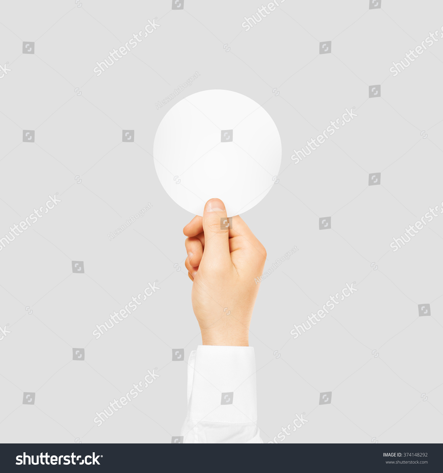 Hand holding round blank white sticker mock up isolated on gray. Sticker mockup holder. Empty paper clue remnder hold in hands. Arm sticking round sticker. #374148292