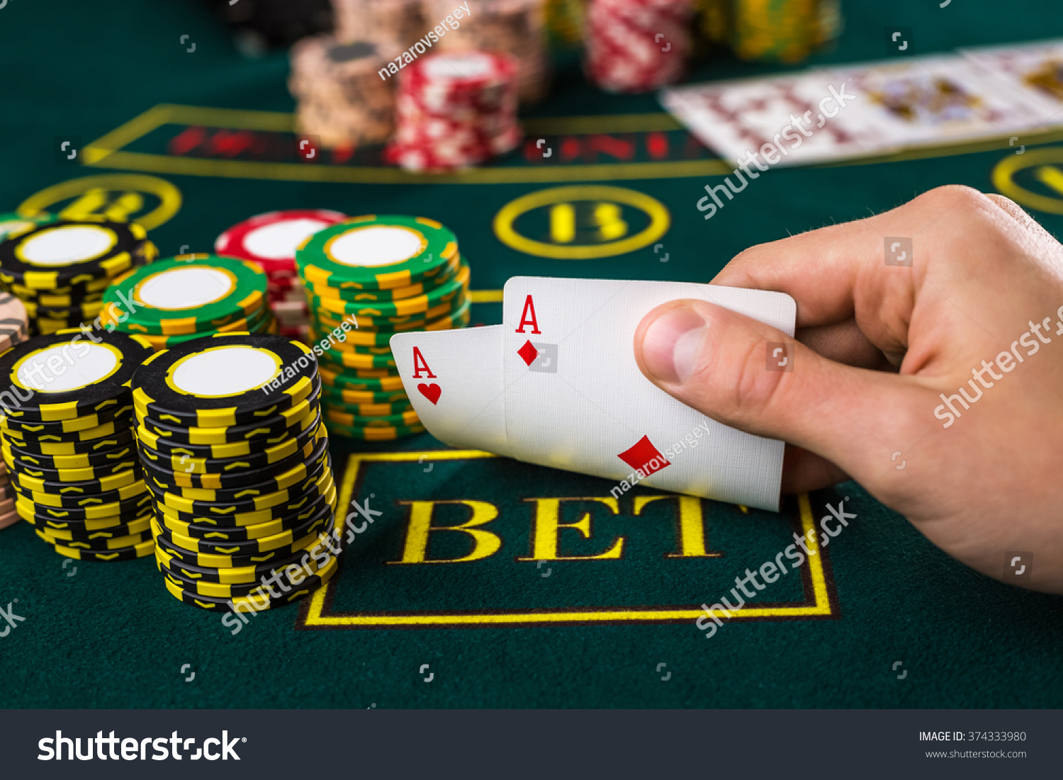 Male poker player lifting the corners of two cards aces  #374333980