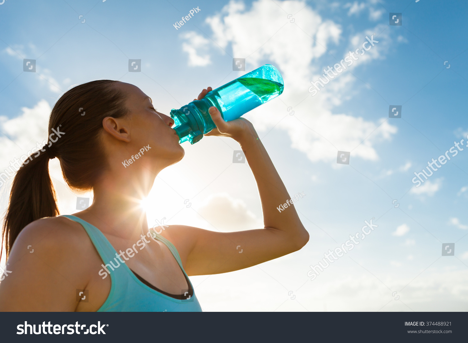 Young female drinking a bottle of water.  #374488921