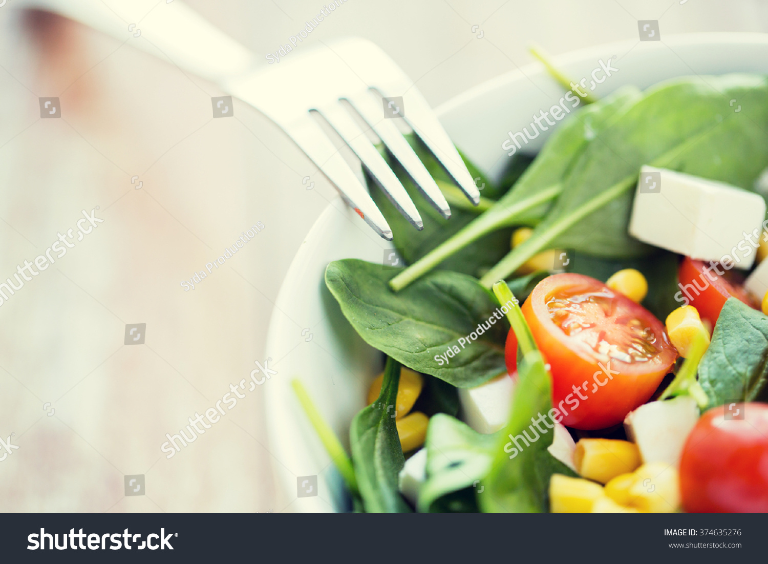 healthy eating, dieting, vegetarian kitchen and cooking concept - close up of vegetable salad bowl and fork at home #374635276