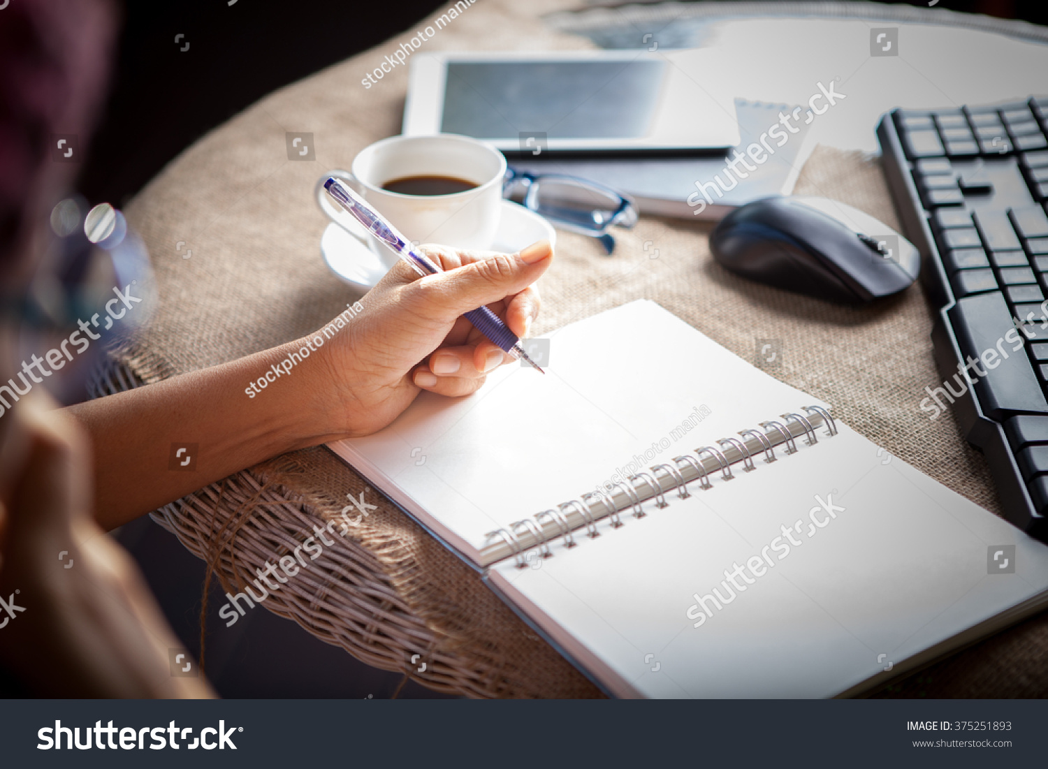 woman left hand writing on paper book ,on table shot #375251893