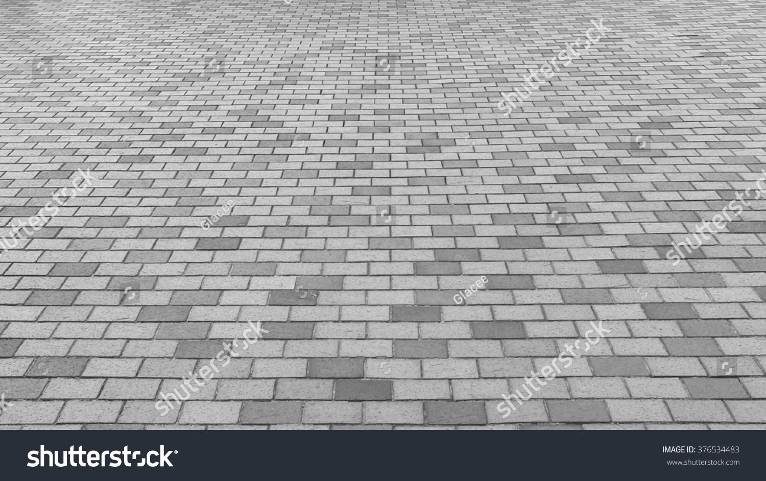 Perspective View Monotone Gray Brick Stone Pavement on The Ground for Street Road. Sidewalk, Driveway, Pavers, Pavement in Vintage Design Ground Flooring Square Pattern Texture Background for mock up #376534483